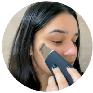 Girl using Ultrasonic Face Scrubber to Lift her Facial Skin
